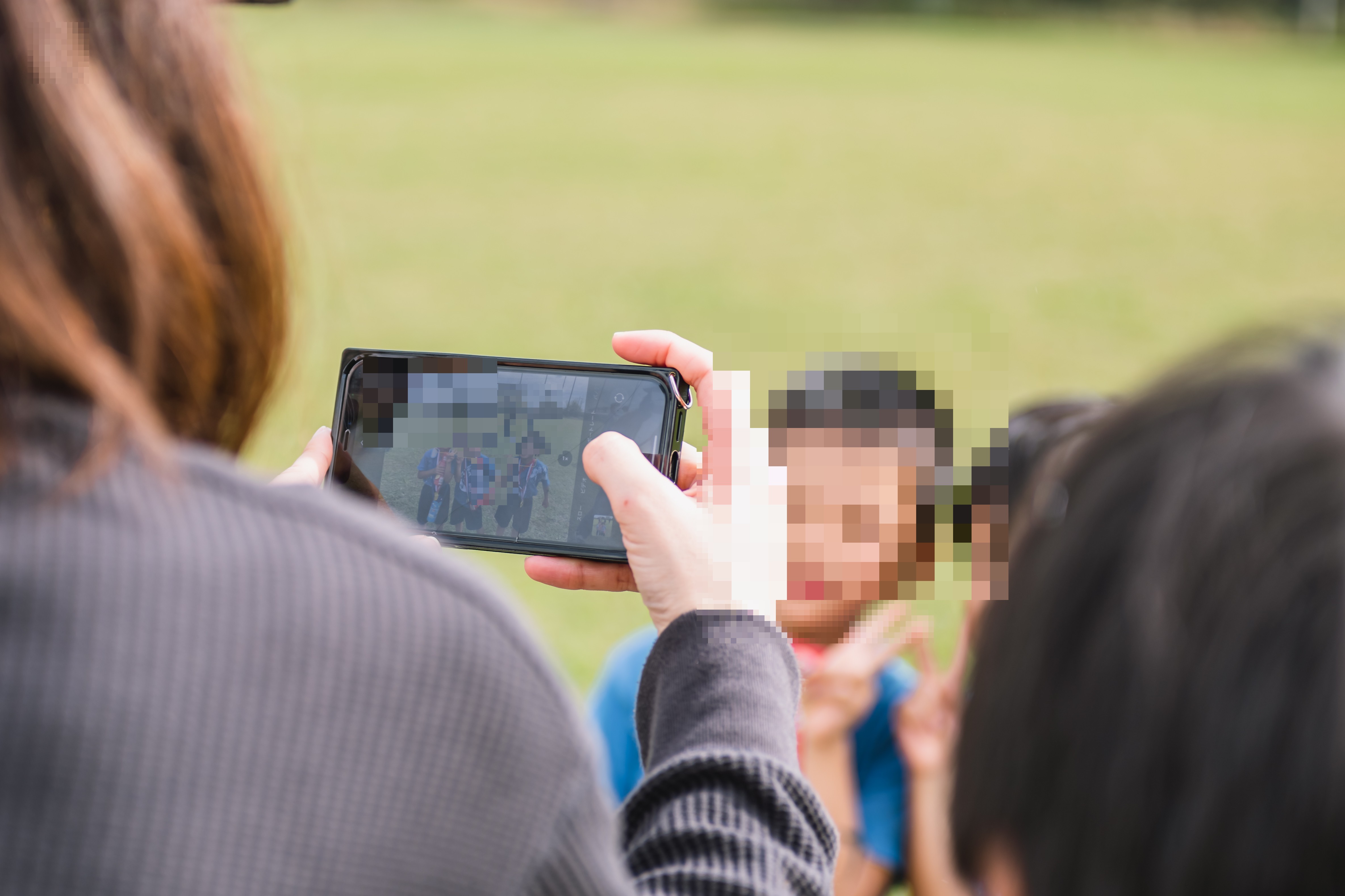スマホでわが子を撮影する保護者